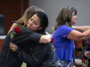 Victims advocate Amy Harlan, left, embraces Savdey Harig of Vancouver after handing her a rose during the annual Day of Remembrance for Homicide Victims at the Public Service Center on Monday. Harig and her husband, Tom, lost their son, Andrew Harig, in August after he was struck by an allegedly intoxicated driver.