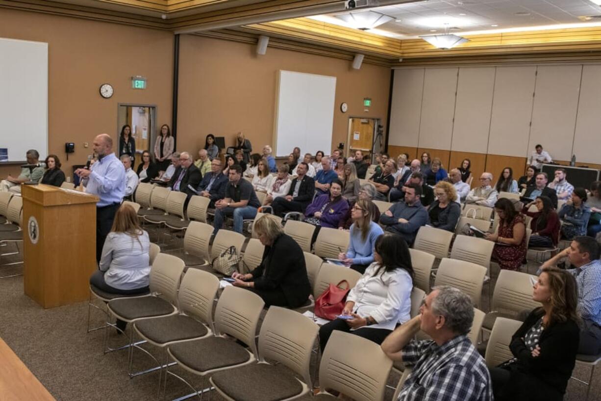 Eric Olmsted, president and founder of On Line Support, voices his opinion from behind the lectern during an Aug. 15 public hearing in Vancouver regarding a proposed increase in the minimum salary required for employees to be exempt from overtime in Washington.