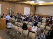 Eric Olmsted, president and founder of On Line Support, voices his opinion from behind the lectern during an Aug. 15 public hearing in Vancouver regarding a proposed increase in the minimum salary required for employees to be exempt from overtime in Washington.