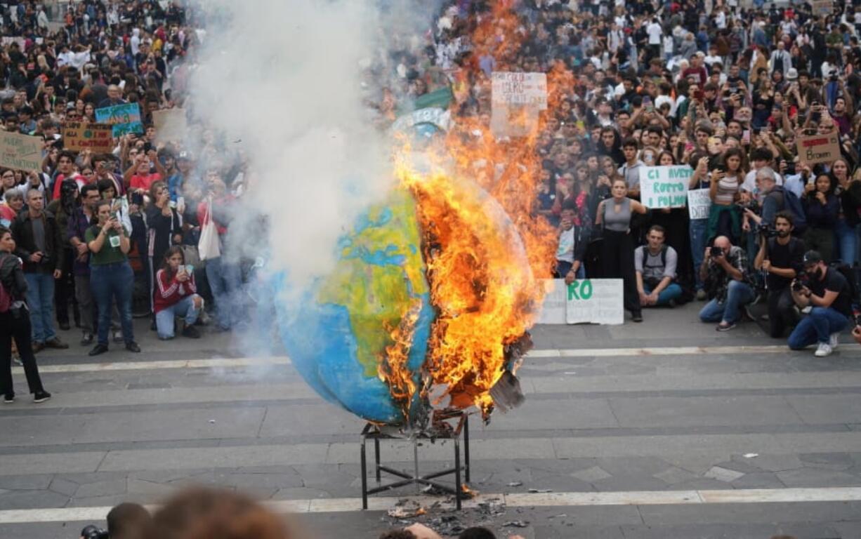 Students set fire to a replica of the planet Earth during a worldwide protest demanding action on climate change, in Milan, northern Italy, Friday, Sept. 27, 2019. The protests are inspired by Thunberg, who spoke to world leaders at a United Nations summit this week.