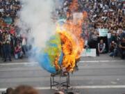 Students set fire to a replica of the planet Earth during a worldwide protest demanding action on climate change, in Milan, northern Italy, Friday, Sept. 27, 2019. The protests are inspired by Thunberg, who spoke to world leaders at a United Nations summit this week.