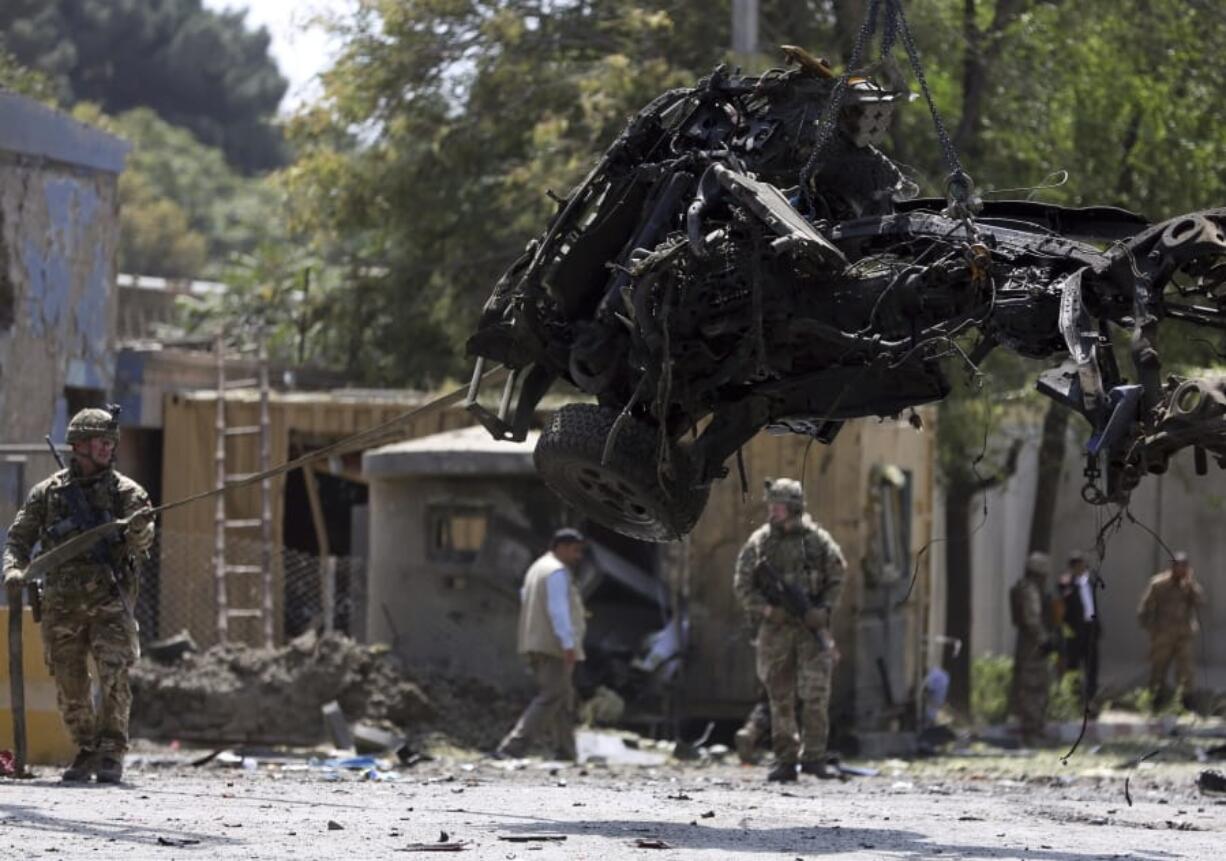 Resolute Support (RS) forces remove a damaged vehicle after a car bomb explosion in Kabul, Afghanistan, Thursday, Sept. 5, 2019. A car bomb rocked the Afghan capital on Thursday and smoke rose from a part of eastern Kabul near a neighborhood housing the U.S. Embassy, the NATO Resolute Support mission and other diplomatic missions.