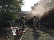 Fire crews battle a blaze at a one-story house and detached garage Thursday in Battle Ground. The fire is being investigated as arson.