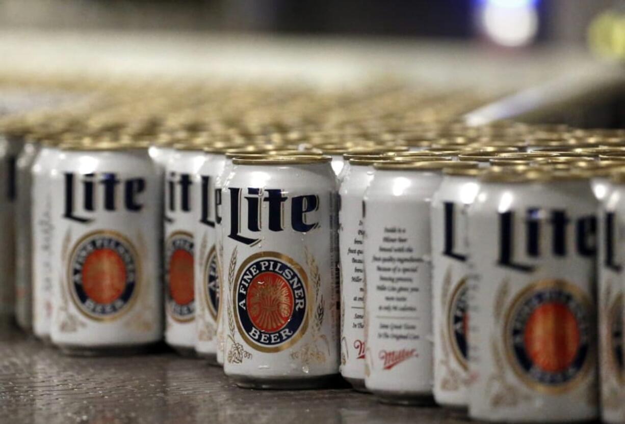 Newly-filled and sealed cans of Miller Lite beer move along on a conveyor belt on March 11, 2015, at the MillerCoors Brewery in Golden, Colo.