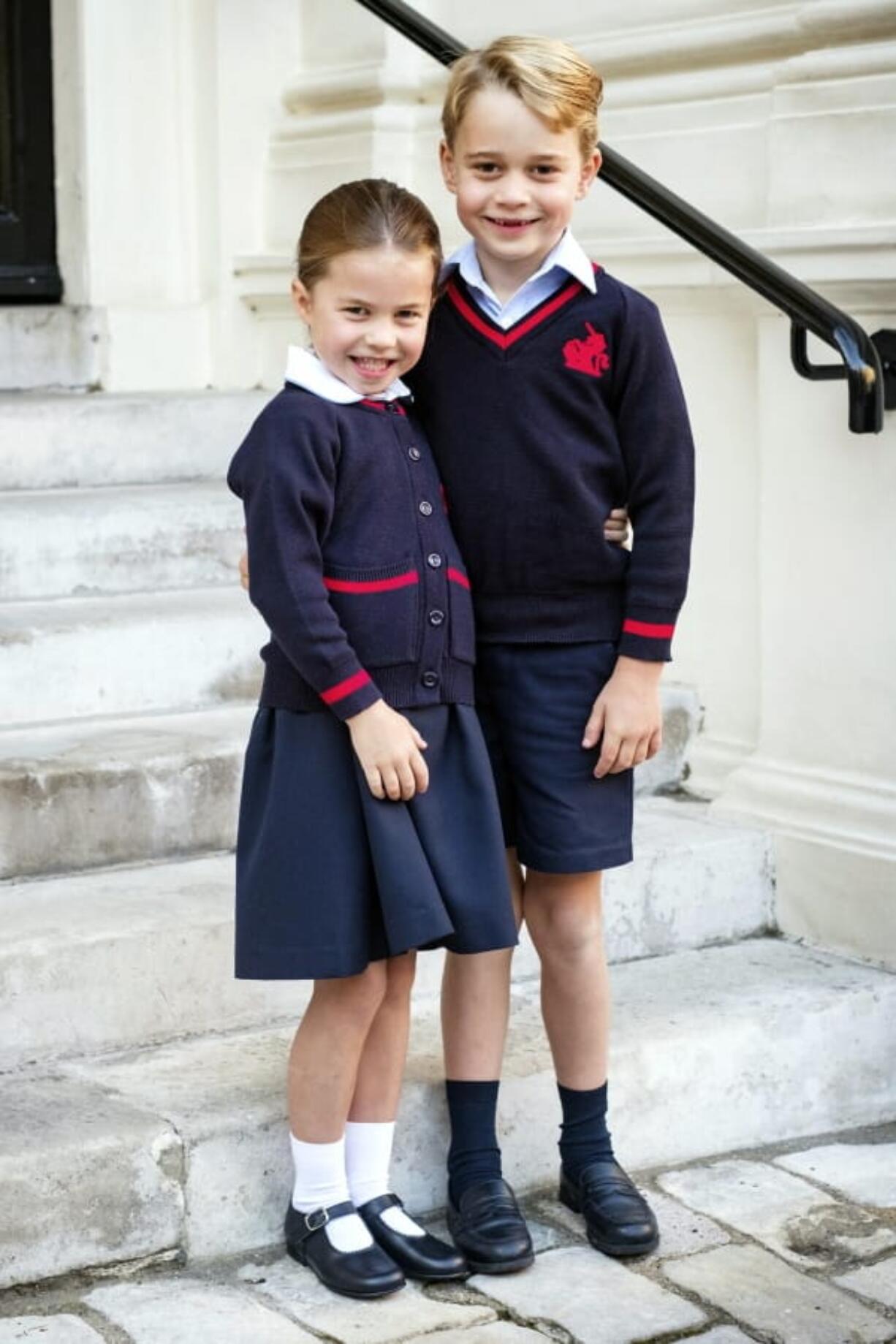 In this photo released by Kensington Palace, Britain’s Princess Charlotte poses with her brother Prince George before her first day of school at Thomas’s Battersea, in London, Thursday, Sept. 5, 2019.