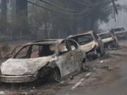 FILE - This Nov. 9, 2018, file photo the burned out hulks of cars abandoned by their drivers sit along a road in Paradise, Calif. In July 2019, the legislature approved and Gov. Gavin Newsom signed a law that requires the state&#039;s three investor-owned utilities to spend a combined $5 billion on safety improvements and adopt new safety standards.