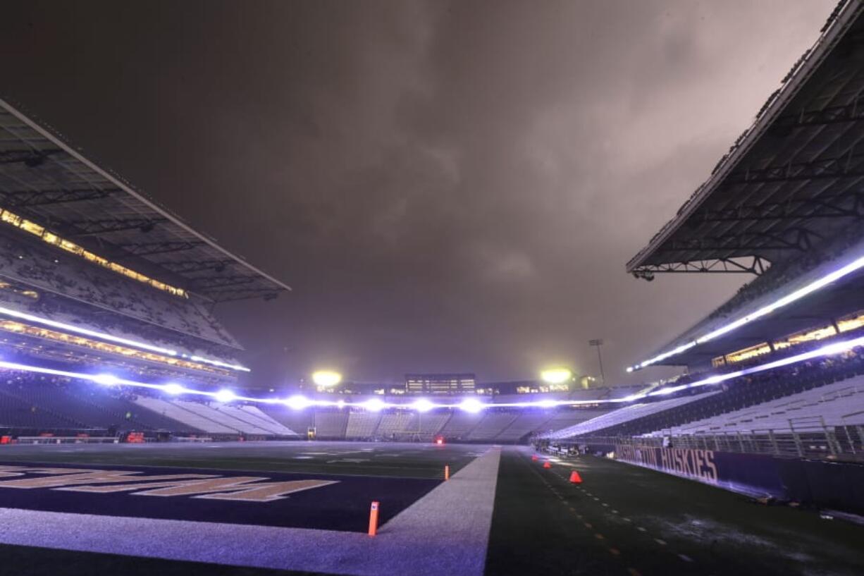 Lightning lights up clouds above Husky Stadium during a weather delay in the first quarter of the game between Washington and California on Saturday. Fans were directed to seek shelter in nearby buildings due to severe weather in the area. Ted S.