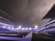 Lightning lights up clouds above Husky Stadium during a weather delay in the first quarter of the game between Washington and California on Saturday. Fans were directed to seek shelter in nearby buildings due to severe weather in the area. Ted S.