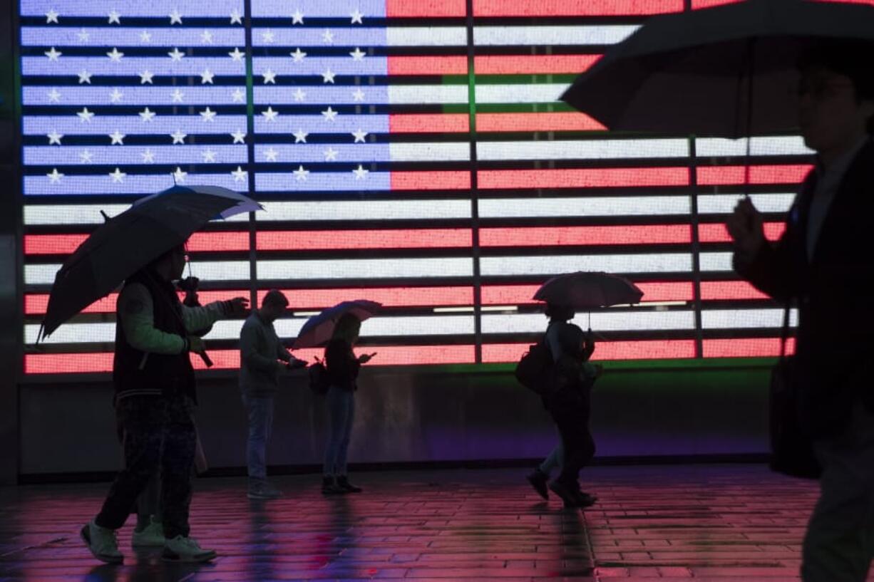 FILE - In this April 26, 2019, file photo, visitors to New York&#039;s Times Square use umbrellas to shield themselves against the rain as they walk past the Armed Forces Recruitment Center. The U.S. Census Bureau is creating tighter privacy controls in response to new fears that census questions could threaten the privacy of the people who answered them.