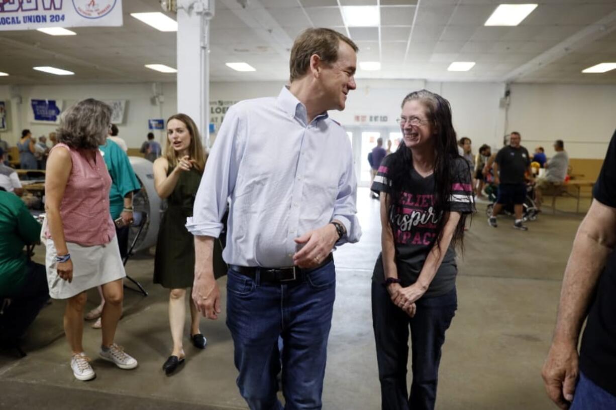 Democratic presidential candidate Sen. Michael Bennet talks with a local resident during the Hawkeye Area Labor Council Labor Day Picnic, Monday, Sept. 2, 2019, in Cedar Rapids, Iowa.