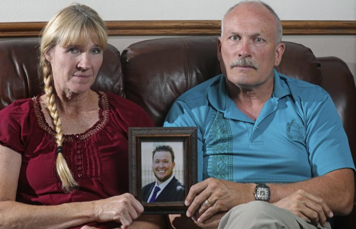 In this Monday, Sept. 9, 2019, photo, Rod and Tonya Meldrum hold a portrait of their son Devin Meldrum, in Provo, Utah. He suffered from debilitating cluster headaches and fatally overdosed after taking a single fentanyl-laced counterfeit oxycodone pill purchased from a dark-web store run by Aaron Shamo, according to his family and authorities. Shamo was not charged in Meldrum&#039;s death, and his lawyers have argued that and other alleged overdoses can&#039;t be definitively linked to him. (AP Photo/Rick Bowmer) (U.S.