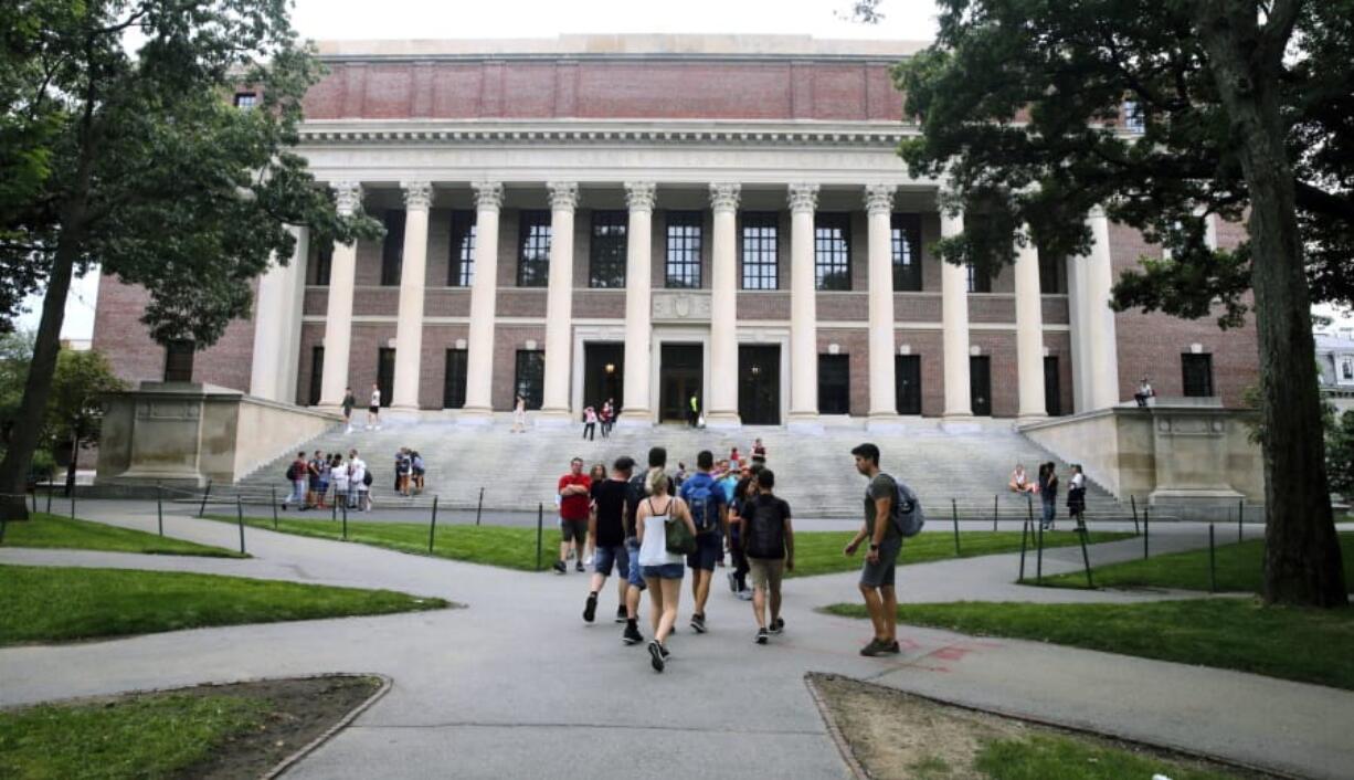 FILE - In this Aug. 13, 2019 file photo, students walk near the Widener Library in Harvard Yard at Harvard University in Cambridge, Mass. University and federal officials confirmed that incoming Harvard University student Ismail Ajjawi, 17, of Lebanon, was refused entry into the U.S. after landing at Logan International Airport in Boston on Friday, Aug. 23.