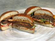 FILE - This Friday, May 3, 2019 file photo shows an Original Impossible Burger, left, and a Cali Burger, from Umami Burger, in New York. A new era of meat alternatives is here, with Beyond Meat becoming the first vegan meat company to go public and Impossible Burger popping up on menus around the country. Several new vegetarian products are competing to win over meat lovers, but two California companies -- Impossible Foods and Beyond Meat -- are grabbing attention for patties that are red before they&#039;re cooked, making them resemble raw beef.