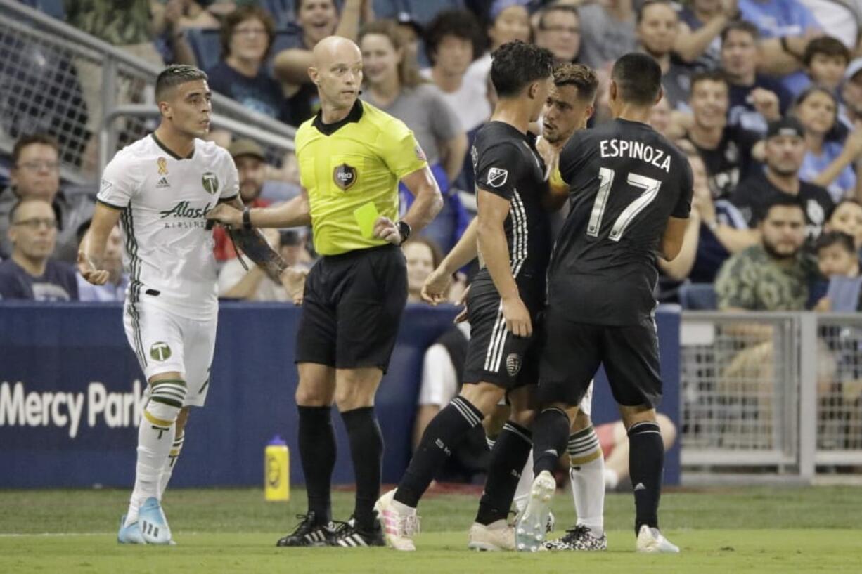 Sporting Kansas City midfielder Roger Espinoza (17) grabs Portland Timbers midfielder Sebastian Blanco (10), second from right during a scuffle in the first half of an MLS soccer game Sunday, Sept. 29, 2019, in Kansas City, Kan.