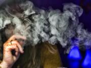 A guest takes a puff of a cannabis vape pen during a marijuana event.