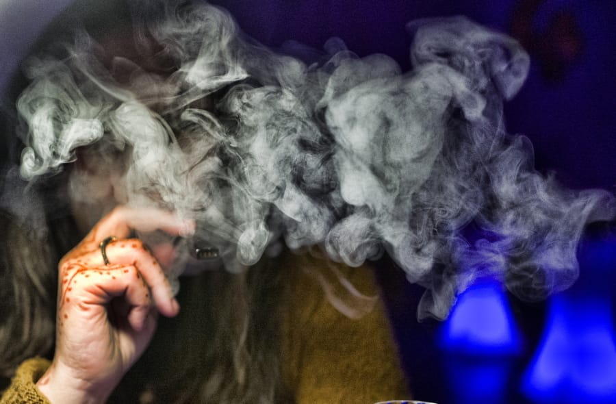 A guest takes a puff of a cannabis vape pen during a marijuana event.