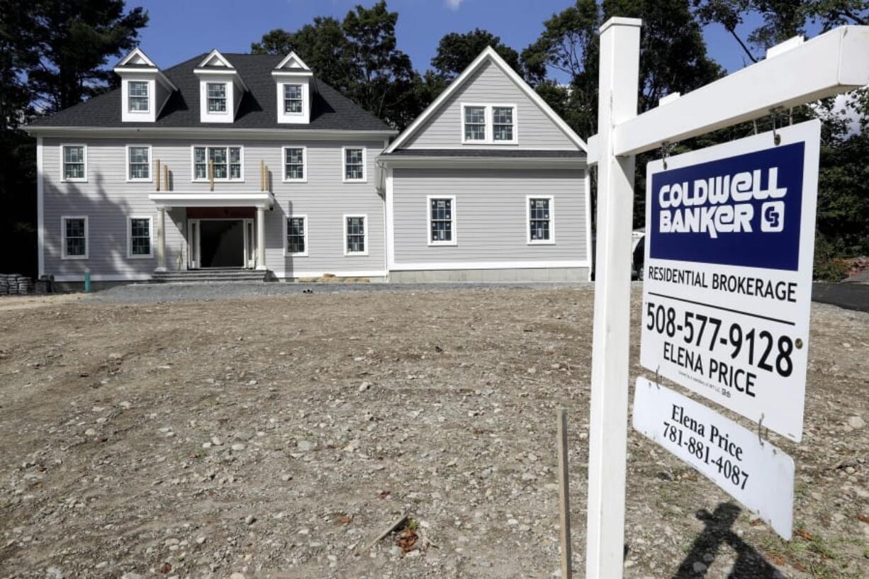 In this Sept. 3, 2019, photo a sign rests in front of a newly constructed home, in Westwood, Mass. On Thursday, Sept. 12, Freddie Mac reports on this week’s average U.S. mortgage rates.