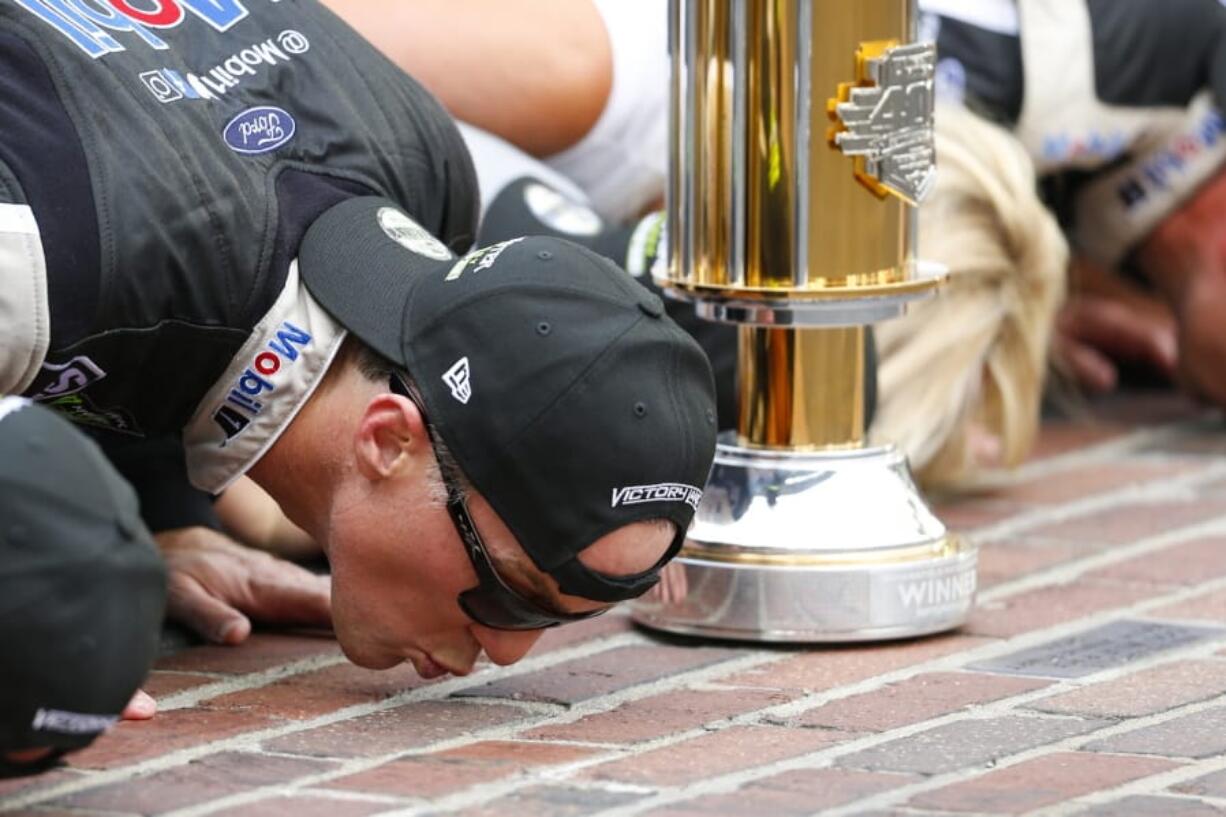 Kevin Harvick kisses the yard of bricks on the finish line after winning the NASCAR Brickyard 400 auto race at Indianapolis Motor Speedway, Sunday, Sept. 8, 2019, in Indianapolis.