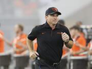 Oregon State coach Jonathan Smith runs onto the field for the team’s NCAA college football game against Oklahoma State in Corvallis, Ore., Friday, Aug. 30, 2019.