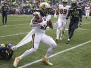 Seattle Seahawks&#039; Shaquill Griffin, left, grabs hold of a piece of uniform as he tries to stop New Orleans Saints&#039; Alvin Kamara on a run during the second half of an NFL football game Sunday, Sept. 22, 2019, in Seattle.