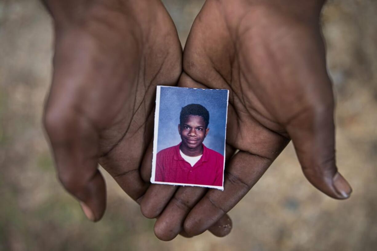 Joshua K. Love, 36, holds a photograph of himself taken at about the time he says he was sexually abused at St. Francis of Assisi School by two Franciscan friars, Brother Paul West and the late Brother Donald Lucas, in Greenwood, Miss., Monday, June 10, 2019.