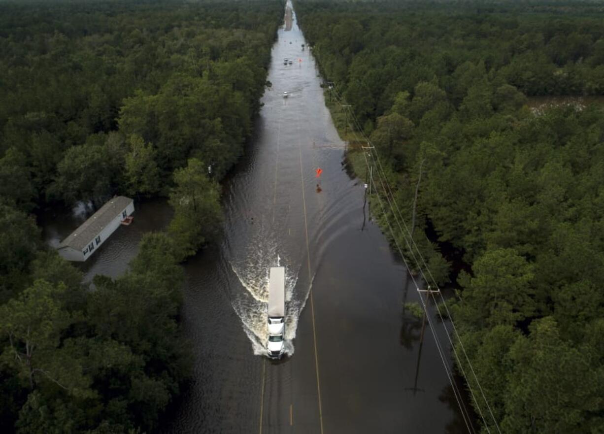 A truck drives through a flooded highway as flooding from the remnants of Tropical Storm Imelda continues in Southeast Texas on Friday, Sept. 20, 2019, in Mauriceville, Texas.