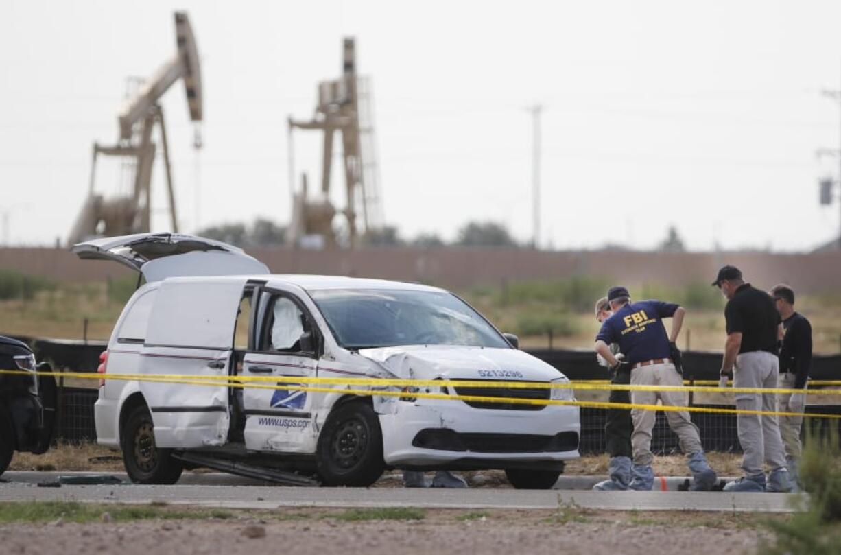 Authorities look at a U.S. Mail vehicle, which was involved in Saturday’s shooting, outside the Cinergy entertainment center Sunday, Sept. 1, 2019, in Odessa, Texas.