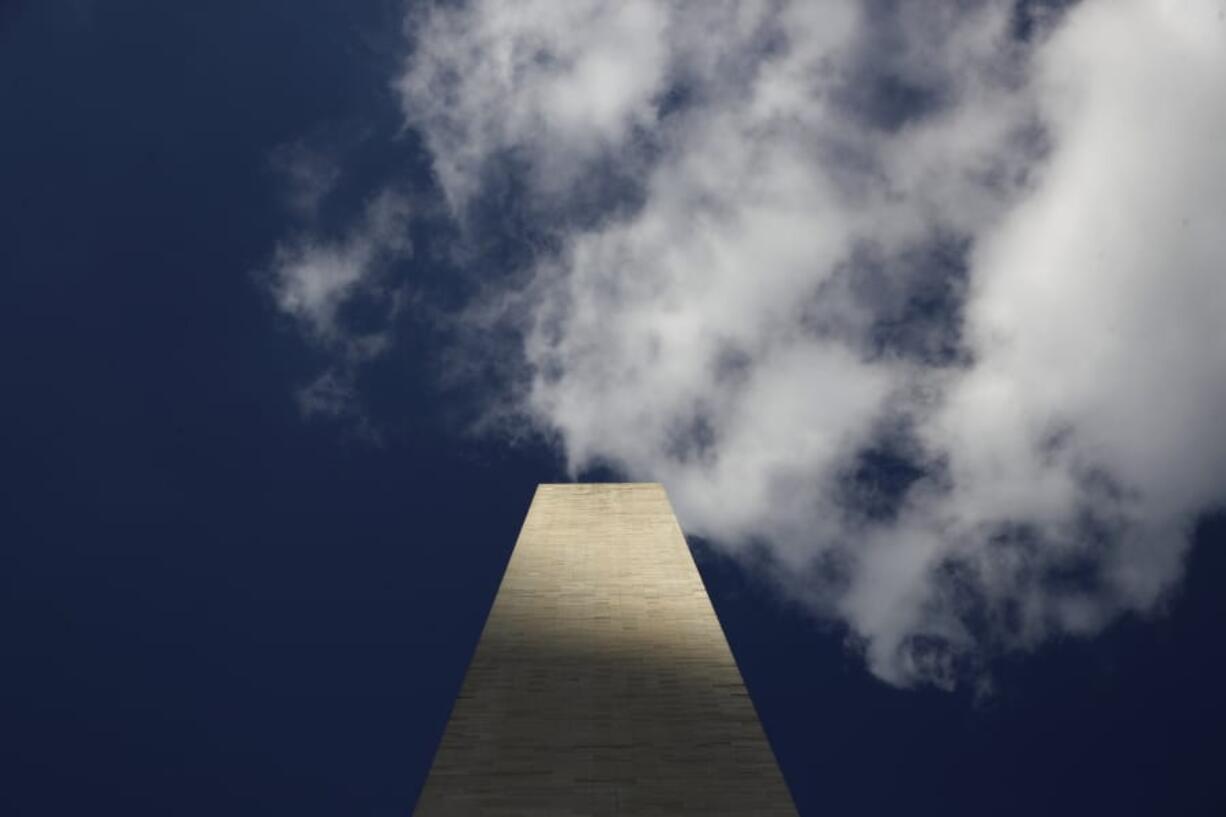 Clouds roll over the Washington Monument, as seen from the foot of the monument Wednesday during a press preview tour ahead of its official reopening.