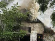 Camas-Washougal fire firefighters battle an outbuilding fire on G Street on Wednesday afternoon.