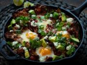 Eggs bake directly in the tortilla chip and tomato sauce mixture. After coming from the oven, the chilaquiles is garnished with avocado, feta and cilantro. Styled by Shannon Kinsella. (E.