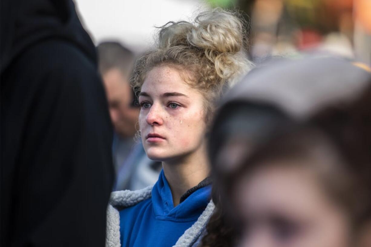 Tiffany Chandler watches her mother, Sharrin Chandler McDade, walk across the stage of the Oct. 5 Portland Out of the Darkness Walk after sharing the story of Tiffany&#039;s sister, Courtney, and father, Justun, who chose to end their lives on the same day about three years ago.