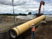 Workers lower a pipe into a trench as part of Oregon&#039;s Willamette Water Supply Program, which will add a new water filtration plant and more than 30 miles of pipeline to accommodate future population growth in the Hillsboro and Tualatin Valley Water District area.