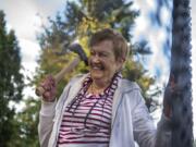 Jo Borwick, 84, laughs while taking aim during an ax throwing event at Highgate Senior Living. Many of the seniors held onto the walls of the mobile ax throwing unit for balance as they threw.