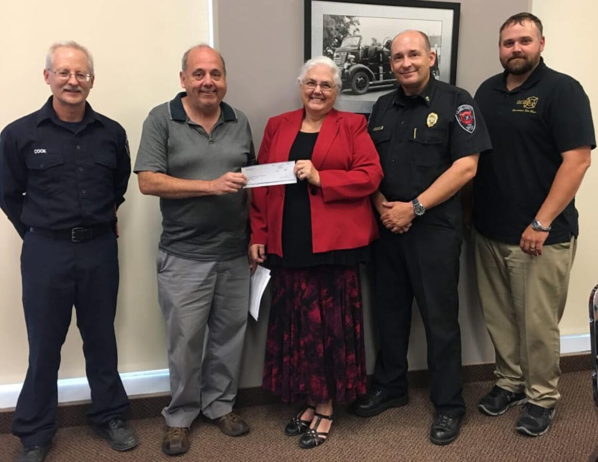 RIDGEFIELD: From Left, Clark County Fire &amp; Rescue Volunteer Smoke Alarm Program Coordinator Tom Cook; CCFR Firefighters Association Treasurer Jack Bothwell; Price Foundation Executive Director Kay Dalke-Sheadel; Clark County Fire &amp; Rescue Fire Chief John Nohr; and Fire Commissioner Stan Chunn stand with a $7,830 grant check that will be used for a supply of smoke alarms.