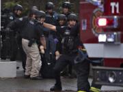 Police carry a wounded woman to safety after a shooting at Smith Tower Apartments on Oct. 3.