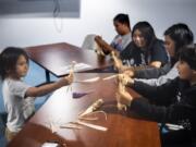 Roberto Ruiz, 4, left, shows off his cornhusk doll to Christian Knack, 9, right, during a potluck at the Cowlitz Indian Tribe building in Hazel Dell on Monday night. The Native American Parent Association of Southwest Washington is trying to revitalize a program for Native American students after area school districts stopped participating in the Title VI Native American Indian Education Program.