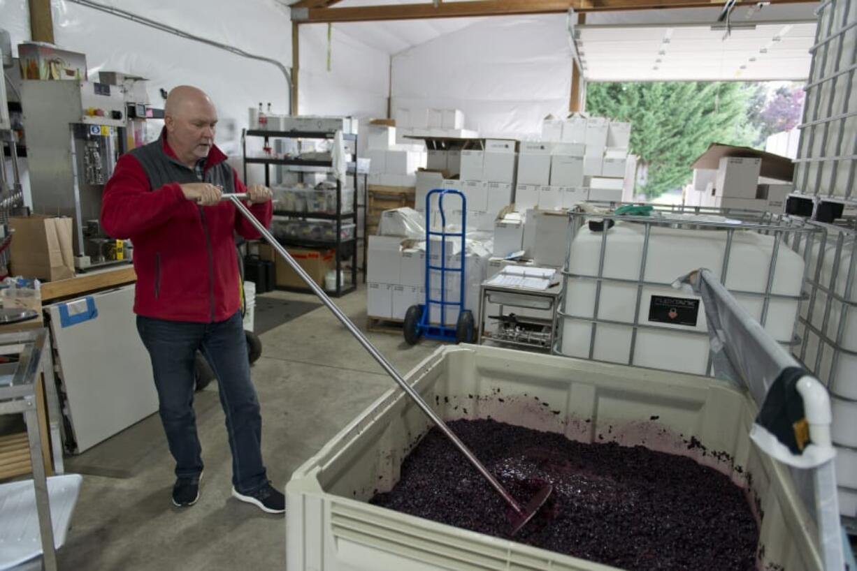 Don Klase mixes wine in a vineyard at Dolio Winery in Battle Ground.