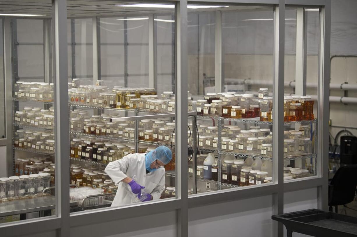 Lab tech Tom Krewson prepares bottles of tobacco-flavored e-liquid while working at River Reserve Eliquid in Vancouver on Thursday. The company is having to scale back making flavored eliquid, which accounts for 90 percent of its products. At top, tobacco-flavored eliquid is the only legal vapor flavor in the state, which was decided by the Washington State Board of Health on Wednesday.