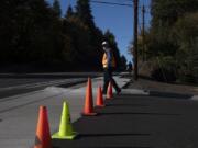 Les MacDonald, the incoming deputy public works director for Clark County, examines a section of new sidewalk along the east side of Highway 99 following a short sidewalk celebration event Thursday afternoon.