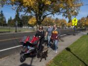 Emily Gillingham, from left, of La Center, and Mitchell Stivers and Alexis Gillingham, both of Battle Ground, take an afternoon stroll together with Gillingham's kids and Stivers and Alexis Gillingham's new puppy along North Parkway Avenue in Battle Ground on Friday.