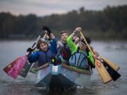 Paula Zellers, left, and Laura Thornquist row at the front of their team's dragon boat on Vancouver Lake. Their team, Catch-22, which is coed and has about 75 members, features close to a dozen people diagnosed with breast cancer. Zellers and Thornquist are two of those people.