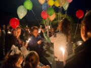 Shannon Melby hands out balloons during a candlelight vigil for 10-year-old Damien Trick on Saturday night, at the intersection where Damien was stuck by a vehicle and killed while riding his bike on Tuesday morning.