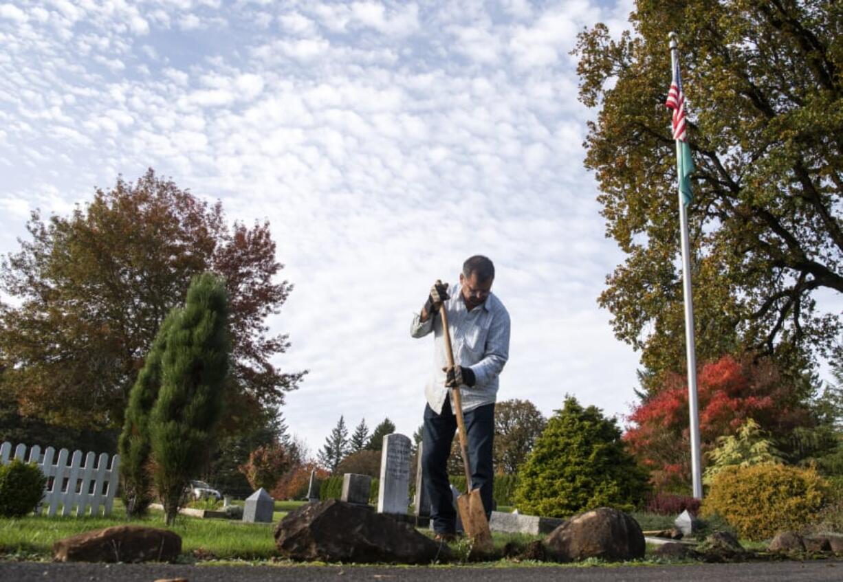 William Zalpys clears away moss buildup on the side of the path at the Fern Prairie Cemetery in Camas. Zalpys has led the cemetery district in the outskirts of Camas since April 2002. He wears many hats in his position, one of which includes groundskeeping, but not grave digging. Cemetery commissioners are elected to six-year terms. Zalpys&#039; term ends in 2023.