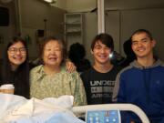 Jung VanAtta visits with her grandchildren, from left, Alexis, Elijah and Trenton Oh, on Wednesday at the hospital after she spent three days lost in the woods in Skamania County.