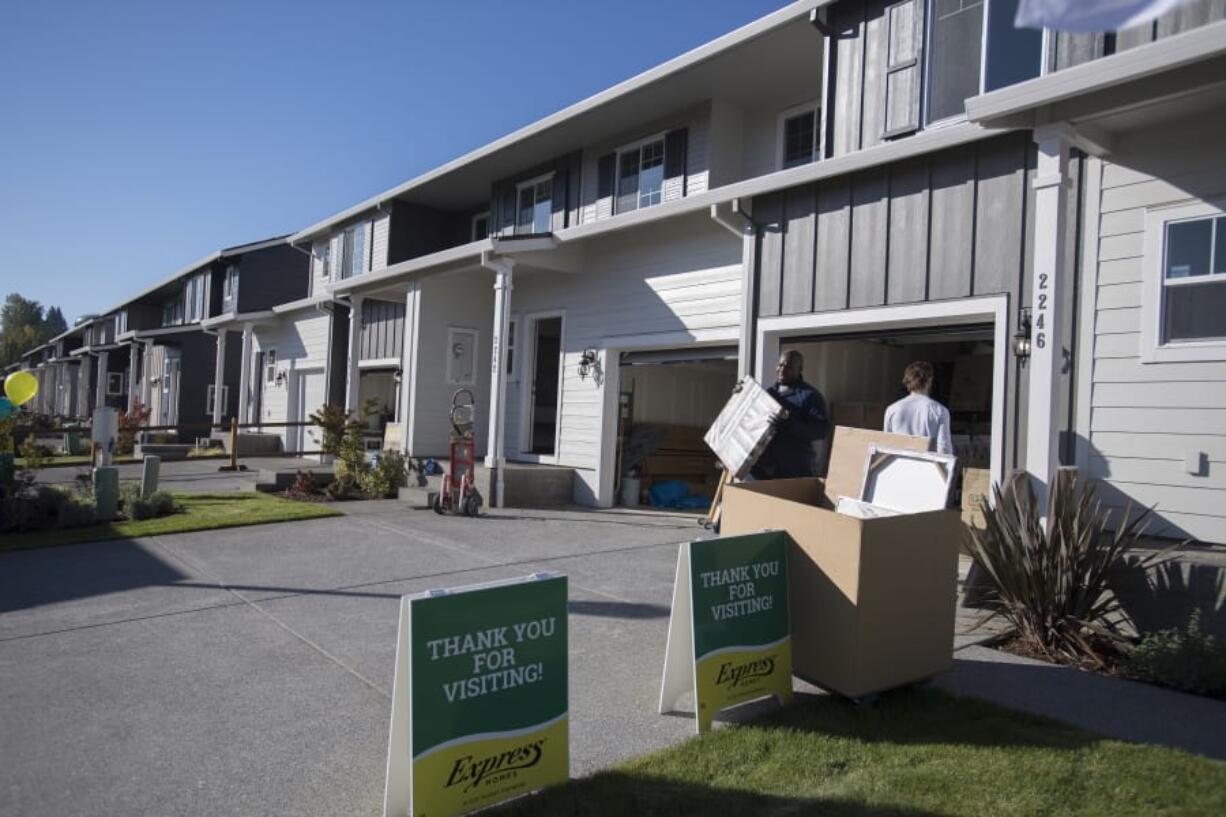 Wendell Wilson of Budget Movers helps move items into a four-plex at the Four Seasons development Thursday morning. The ongoing project from Ginn Development contributed to a spike in the number of single-family building permits issued by the city of Vancouver last month.