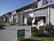 Wendell Wilson of Budget Movers helps move items into a four-plex at the Four Seasons development Thursday morning. The ongoing project from Ginn Development contributed to a spike in the number of single-family building permits issued by the city of Vancouver last month.