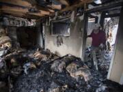 Mark Evans of Washougal removes charred items from the interior of Wanda Walker LMP, one of four businesses damaged by a fire early Sunday morning.