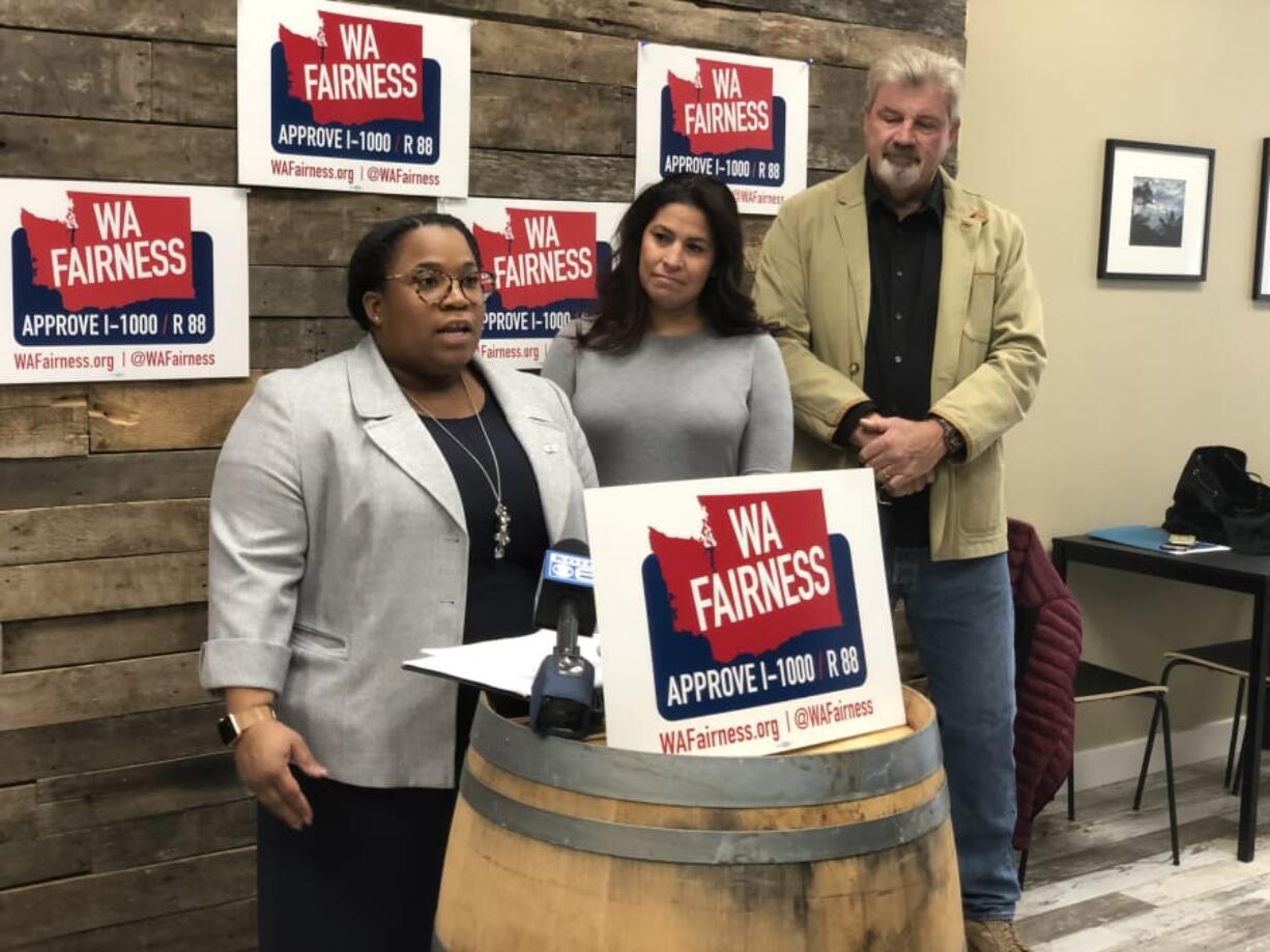 Cherika Carter, WA Fairness campaign manager, speaks during Tuesday's news conference supporting Referendum 88 as state Rep. Monica Stonier, D-Vancouver, and Steven Johnson, a member of VoteVets.org, listen.