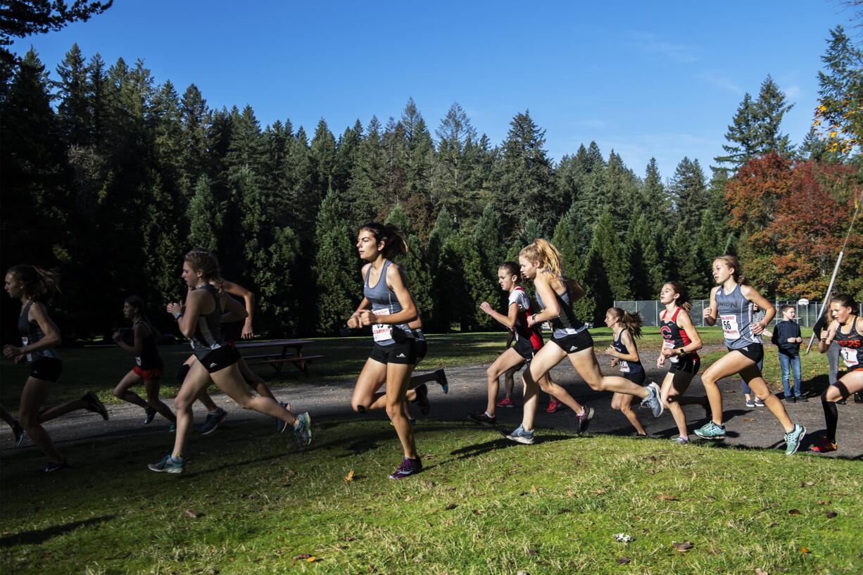 Runners take a turn during the girls 4A district cross country meet at Lewisville Park on Wednesday afternoon, Oct. 23, 2019.