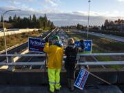 Lehman Holder, left, and Sharon Fujioka, both with the Sierra Club, campaign for various Vancouver candidates Friday on the Interstate 205 overpass on Northeast Ninth Street in Vancouver.